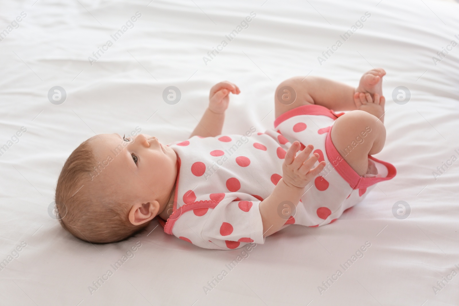 Photo of Cute little baby lying on bed at home