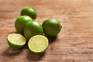 Photo of Fresh ripe limes on wooden table. Citrus fruit