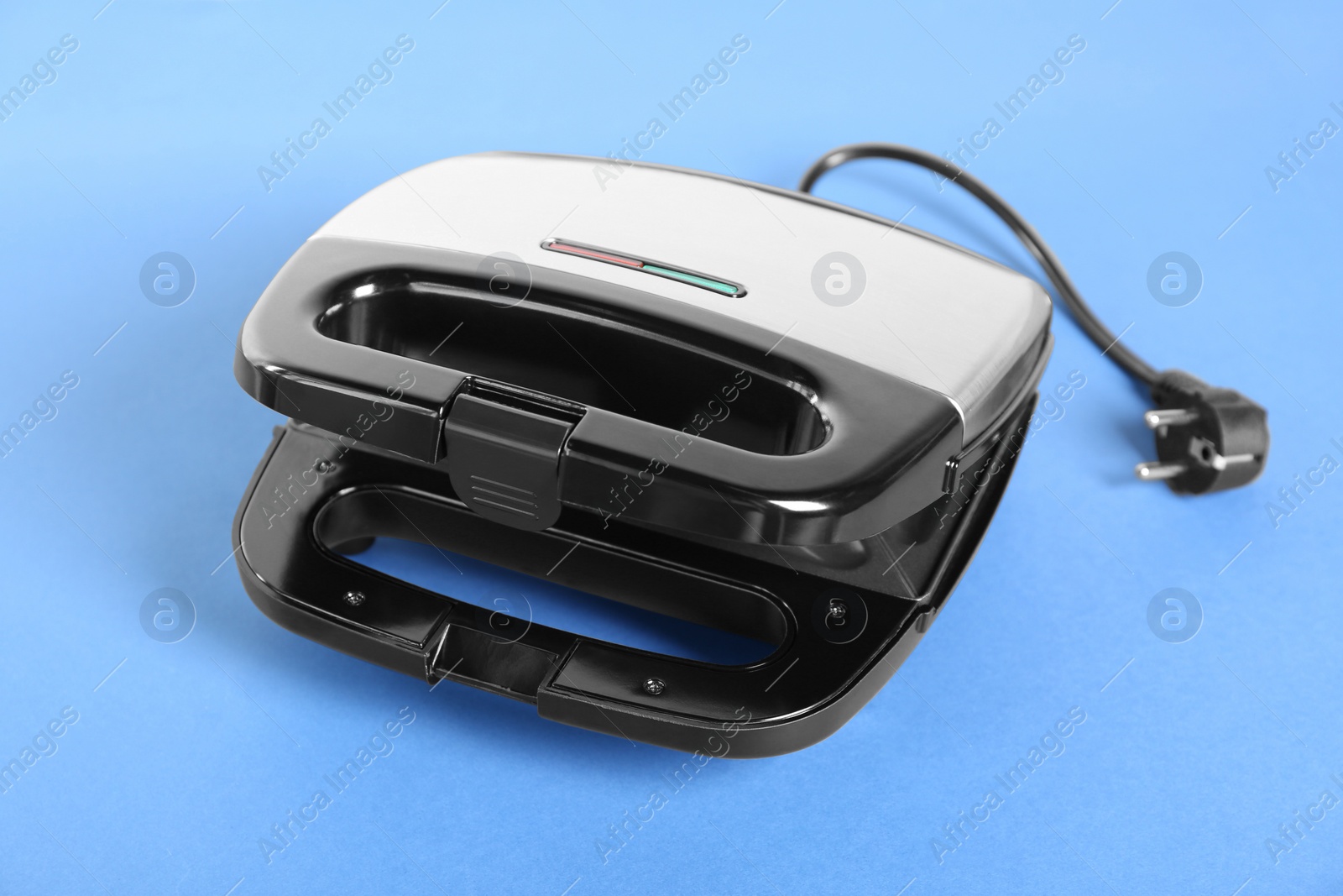 Photo of Open sandwich maker on light blue background