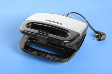 Photo of Open sandwich maker on light blue background