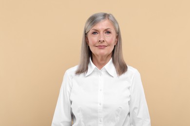 Photo of Portrait of beautiful senior woman on beige background