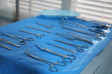 Photo of Different surgical instruments on blue table indoors