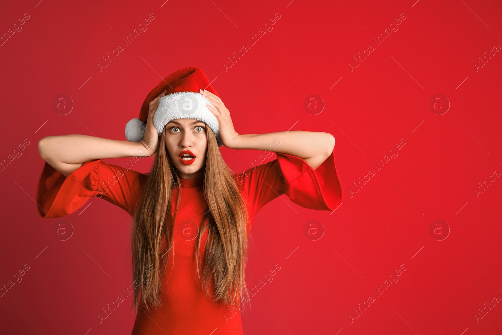 Photo of Young beautiful woman in Santa hat on color background. Christmas celebration