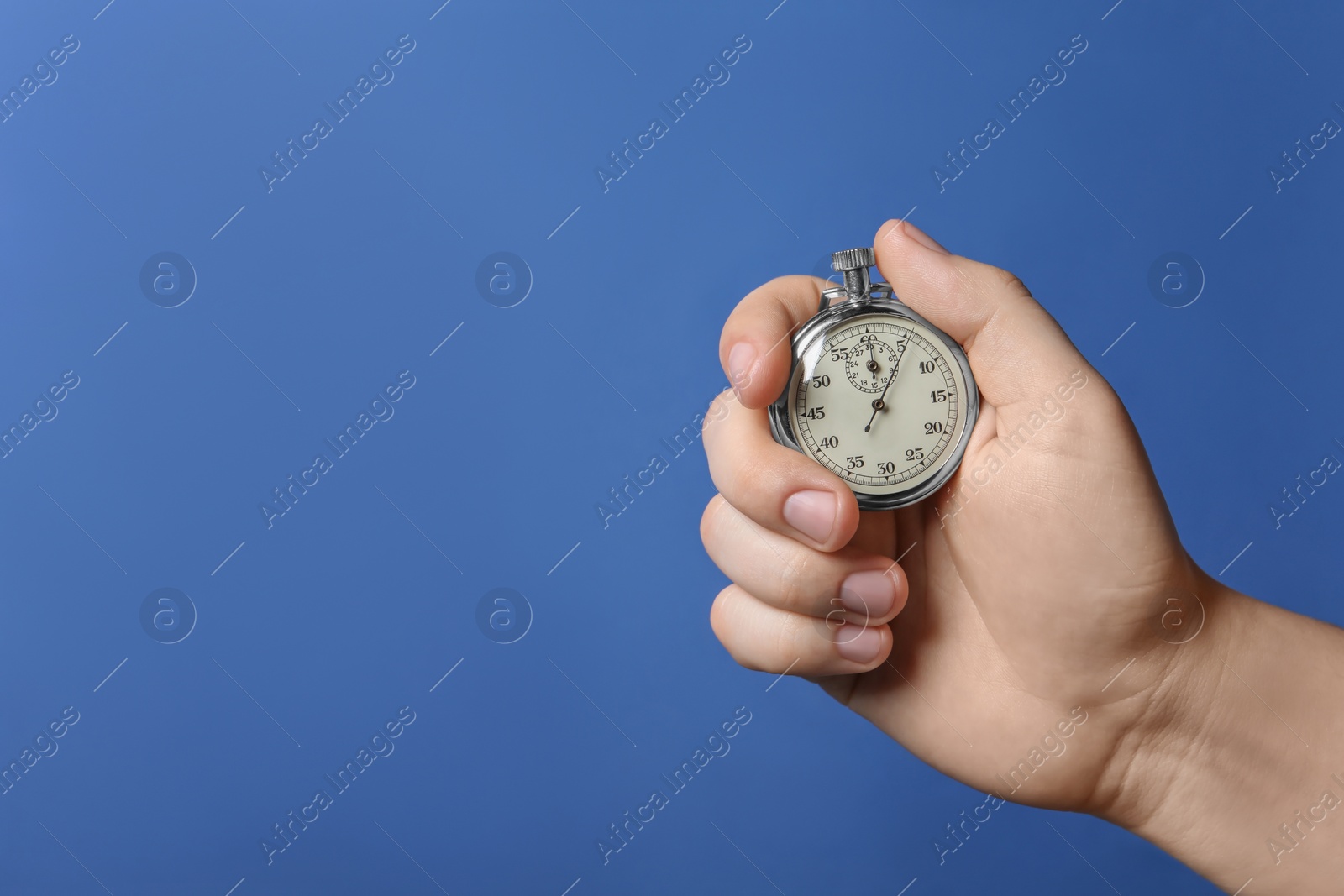 Photo of Man holding vintage timer on blue background, closeup. Space for text