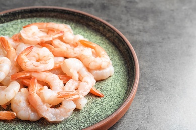 Plate with fresh shrimps on gray background