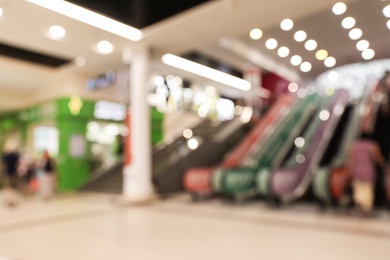 Photo of Blurred view of modern shopping mall with escalators. Bokeh effect