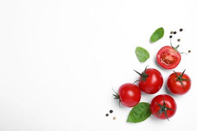 Photo of Fresh green basil leaves, spices with cut and whole tomatoes on white background, top view