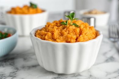 Bowl of tasty sweet potato puree on marble table