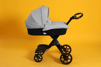 Photo of Baby carriage. Modern pram on yellow background