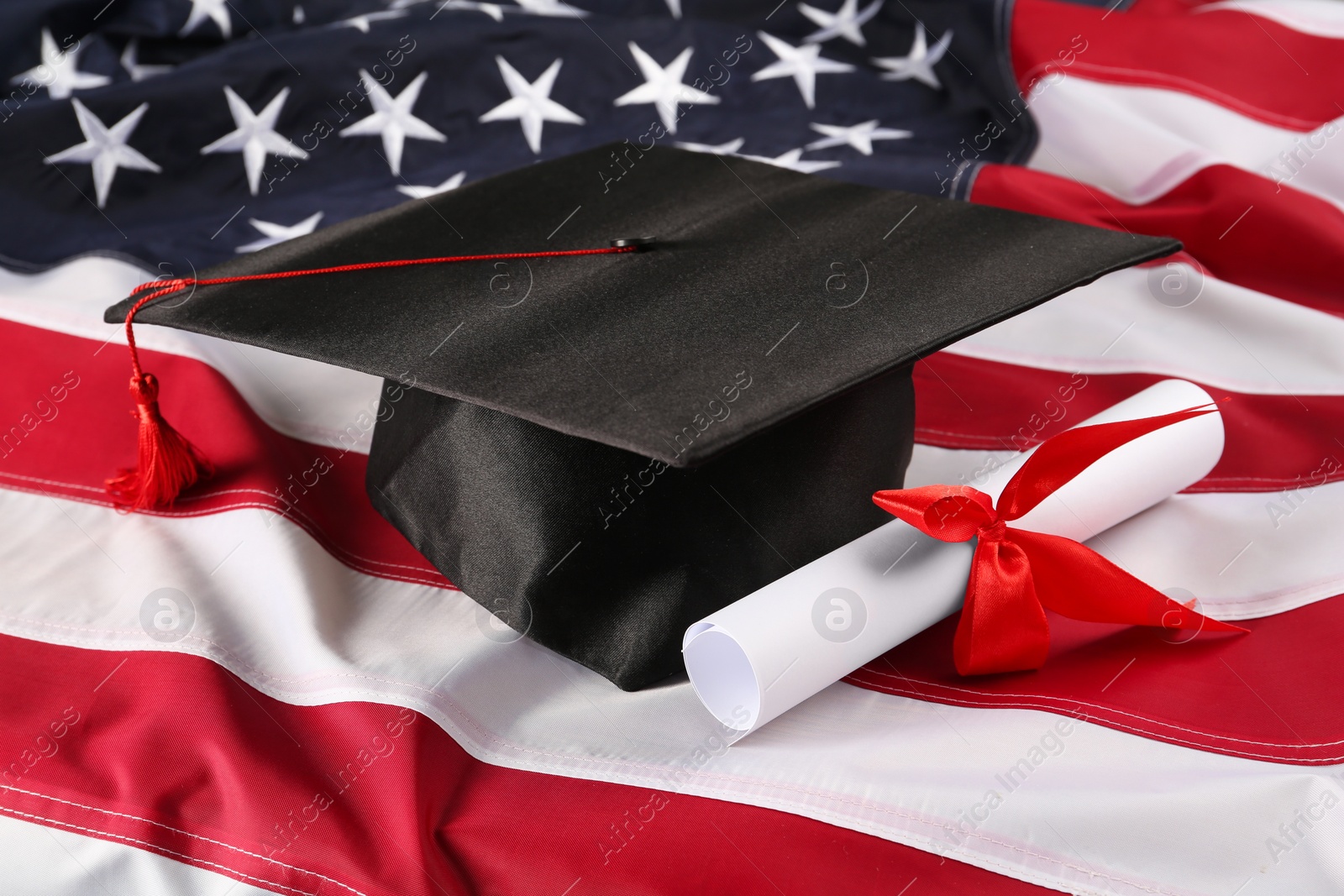 Photo of Graduation hat and diploma on flag of United States