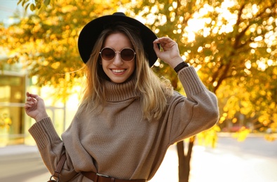 Beautiful young woman wearing stylish sweater in autumn park