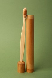 Photo of Bamboo toothbrush and case on green background. Conscious consumption