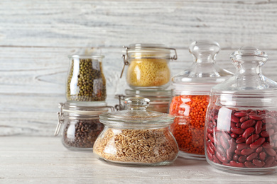 Photo of Different types of legumes and cereals on wooden table. Organic grains