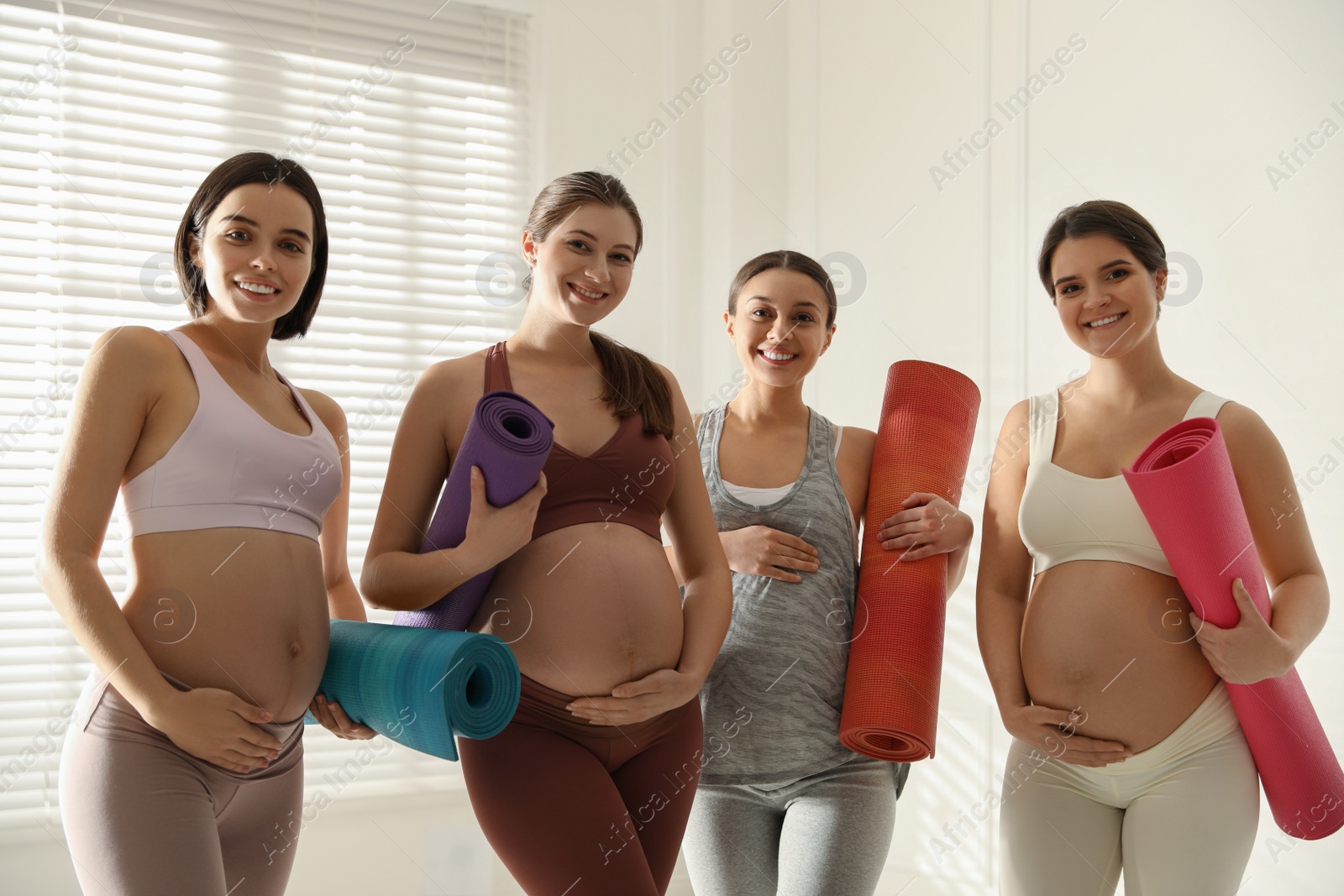 Photo of Group of pregnant women with mats in yoga class