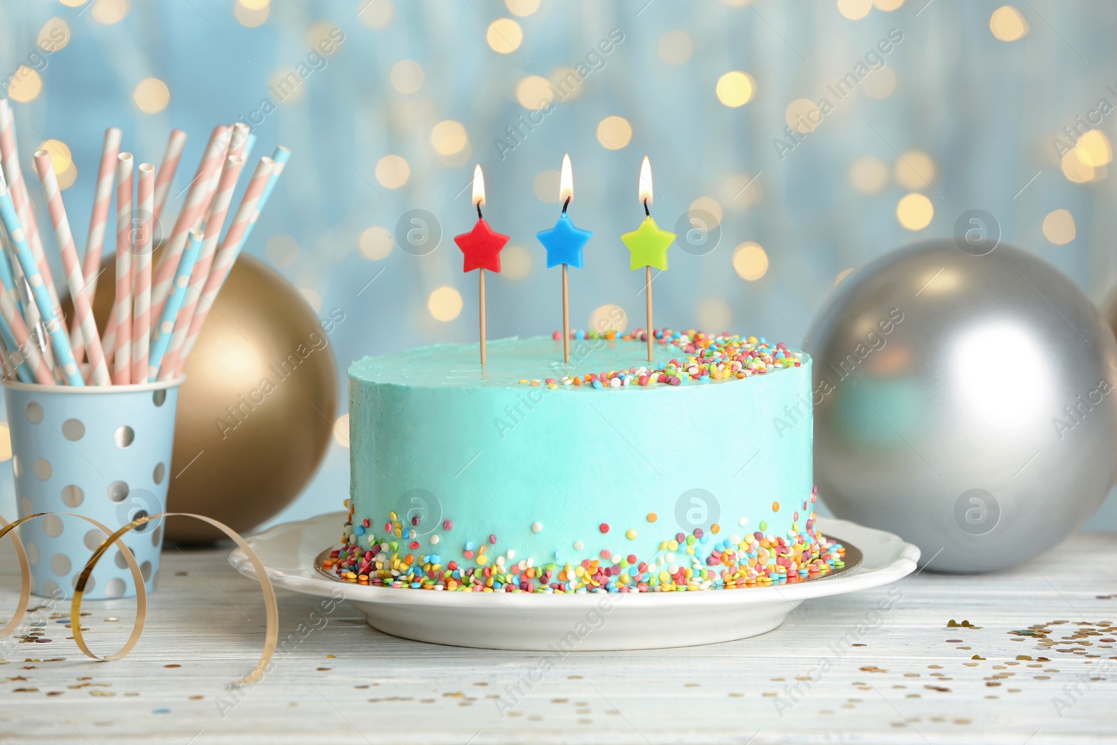 Photo of Fresh delicious cake with candles on table against blurred lights