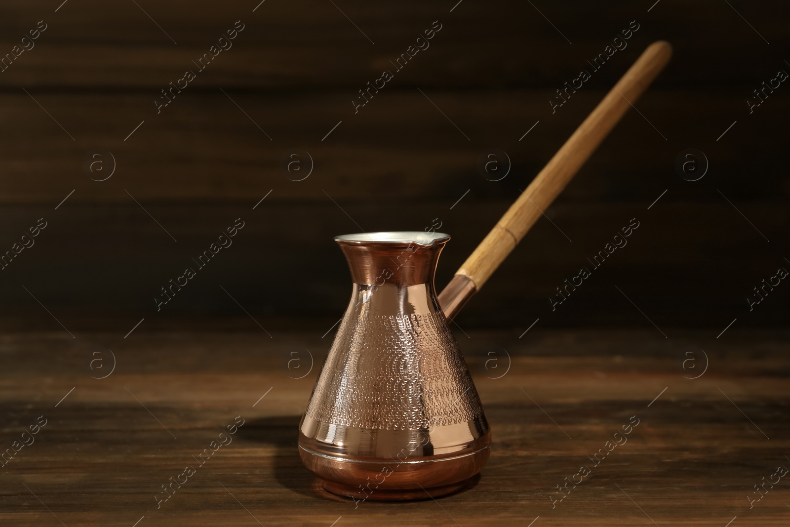 Photo of Beautiful copper turkish coffee pot on wooden table