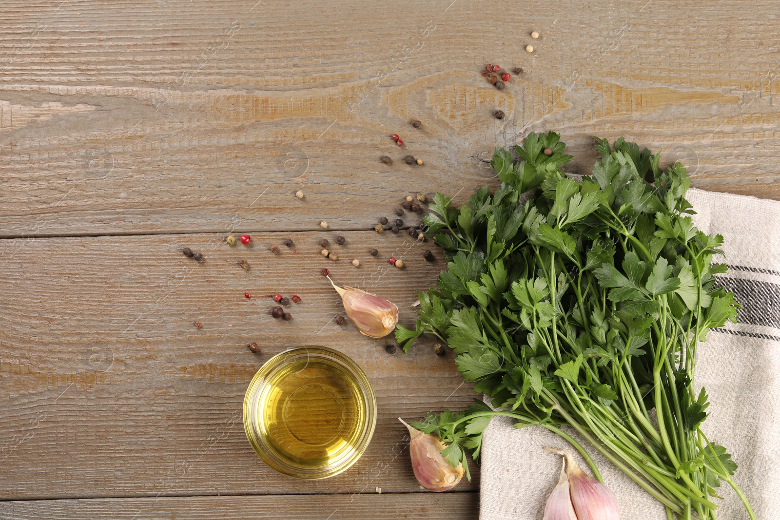 Photo of Bunch of raw parsley, oil, garlic and peppercorns on wooden table, flat lay. Space for text