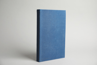 Photo of Hardcover book on light grey background. Space for design