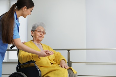 Nurse assisting senior woman in wheelchair at hospital