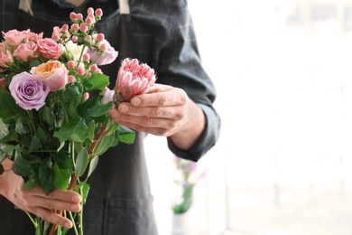 Male florist holding beautiful bouquet, closeup