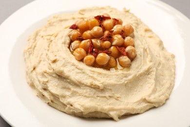 Photo of Plate of tasty hummus with chickpeas, closeup