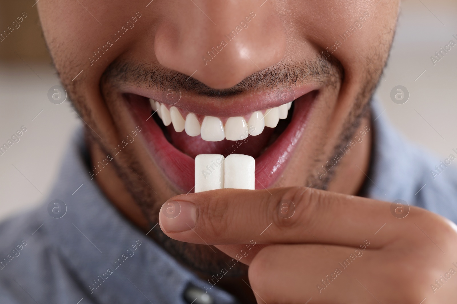 Photo of Man with chewing gums on blurred background, closeup