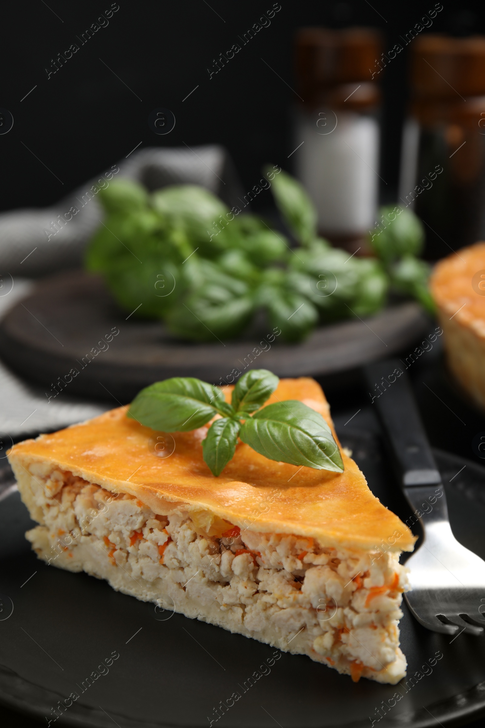 Photo of Piece of delicious pie with meat and basil in plate, closeup