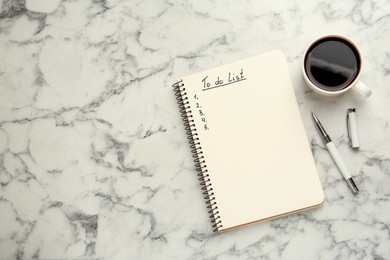 Photo of Notepad with unfilled To Do list, pen and cup of coffee on white marble table, flat lay. Space for text