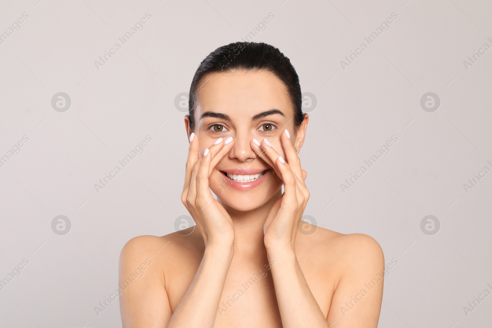 Photo of Beautiful young woman with perfect skin on light grey background