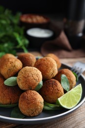 Delicious falafel balls with lime on table, closeup