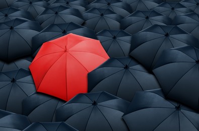 Image of Red umbrella standing out of other ones, above view