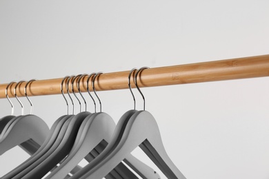 Photo of Wooden rack with clothes hangers on white background, closeup