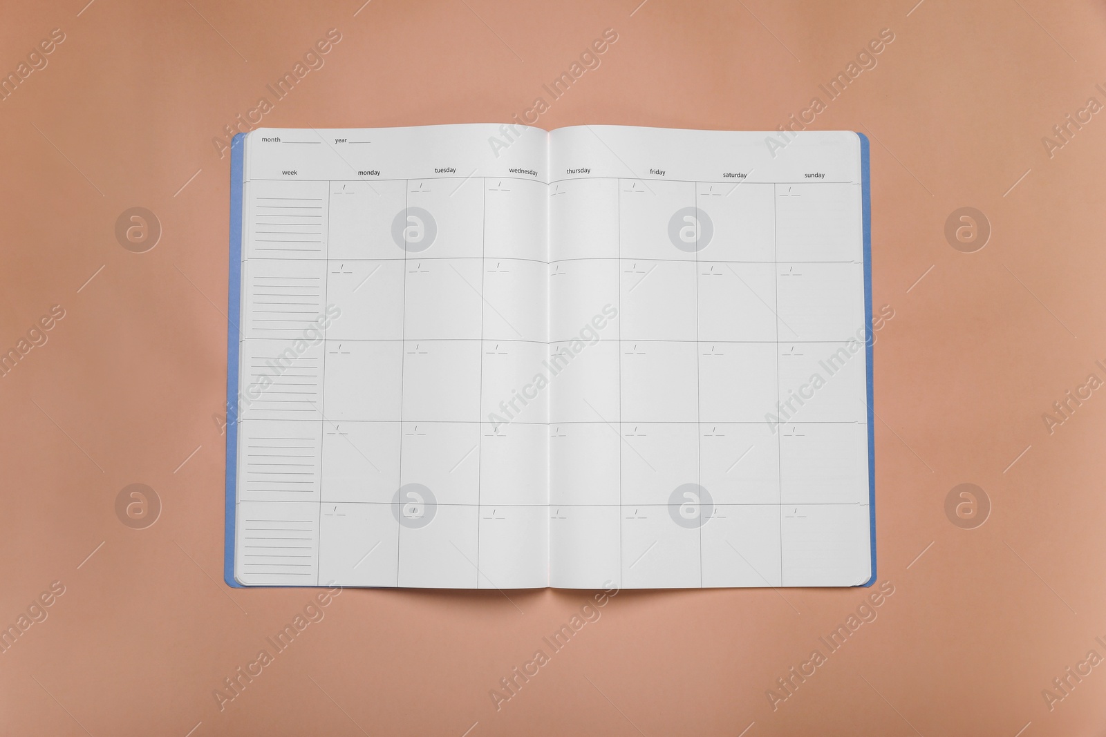 Photo of Open monthly planner on beige background, top view