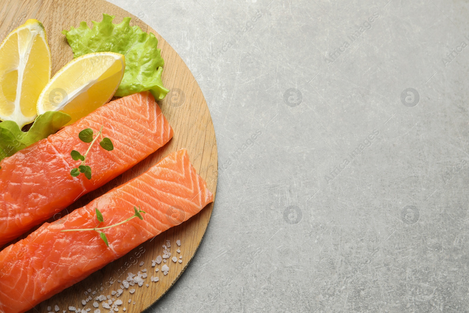 Photo of Fresh raw salmon and ingredients for marinade on light grey table, top view. Space for text