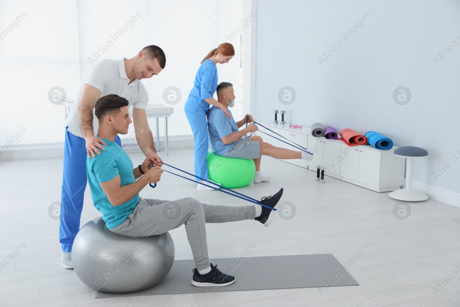 Photo of Professional physiotherapists working with patients in rehabilitation center