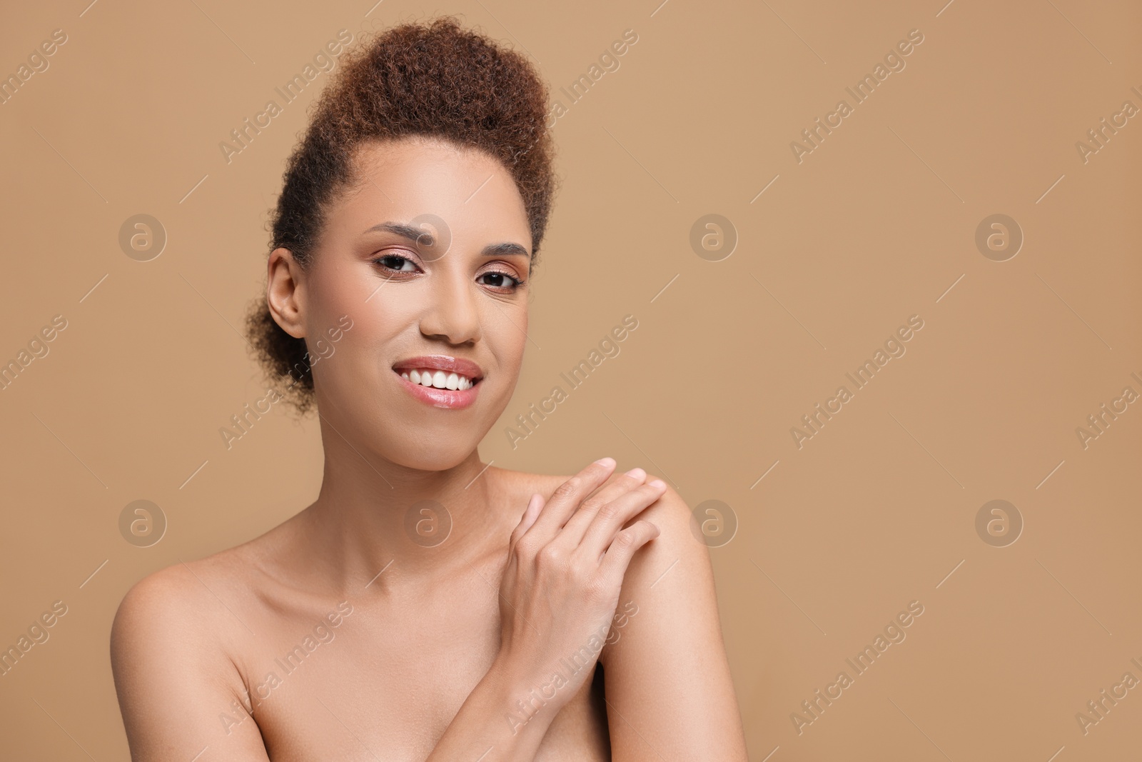 Photo of Portrait of beautiful young woman with glamorous makeup on light brown background. Space for text