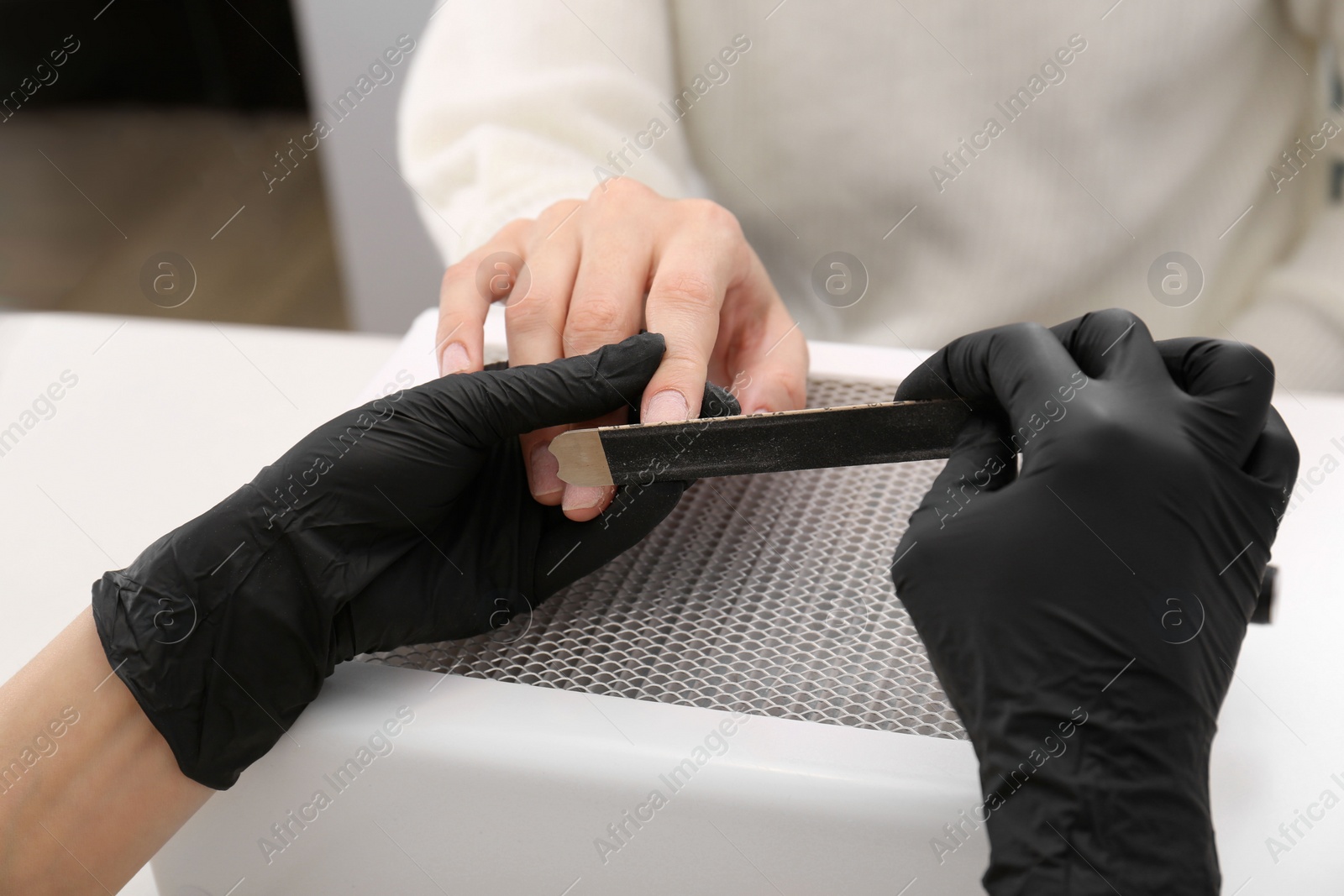 Photo of Professional manicurist working with client, closeup view