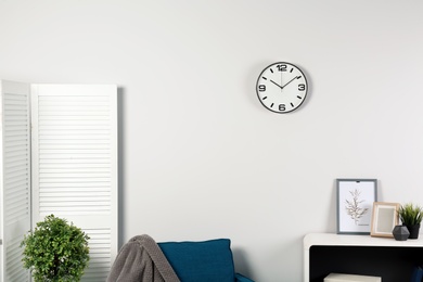 Photo of Room interior with clock on wall. Time management