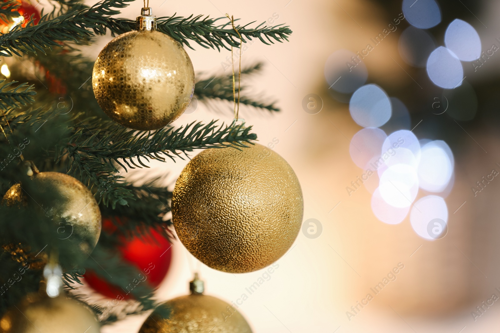 Photo of Christmas tree decorated with festive balls on light background, closeup. Space for text