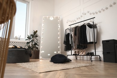 Stylish dressing room interior with trendy clothes and shoes