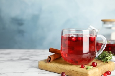 Photo of Tasty hot cranberry tea and fresh ingredients on white marble table. Space for text
