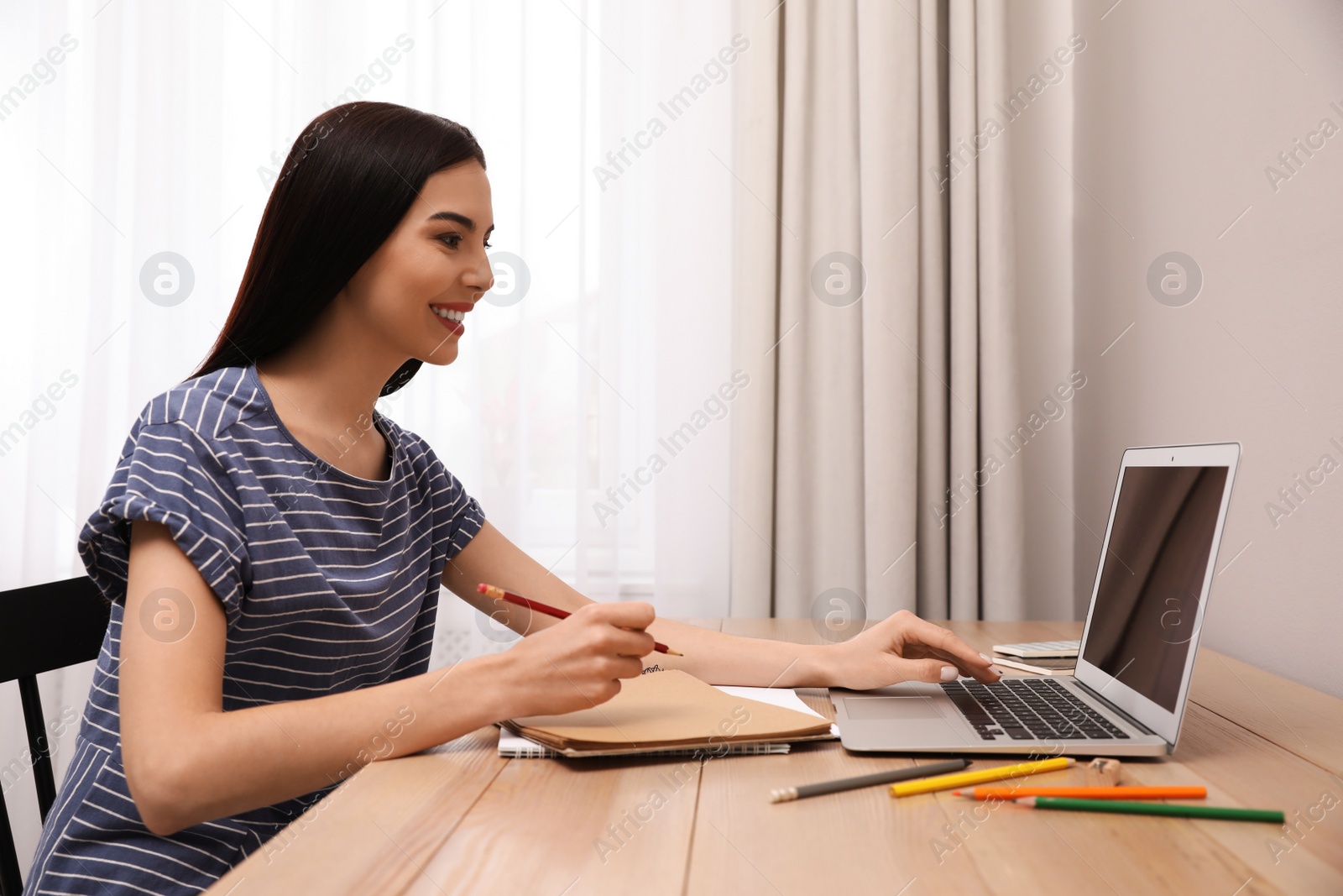 Photo of Happy woman drawing picture at online art lesson indoors. Distant learning