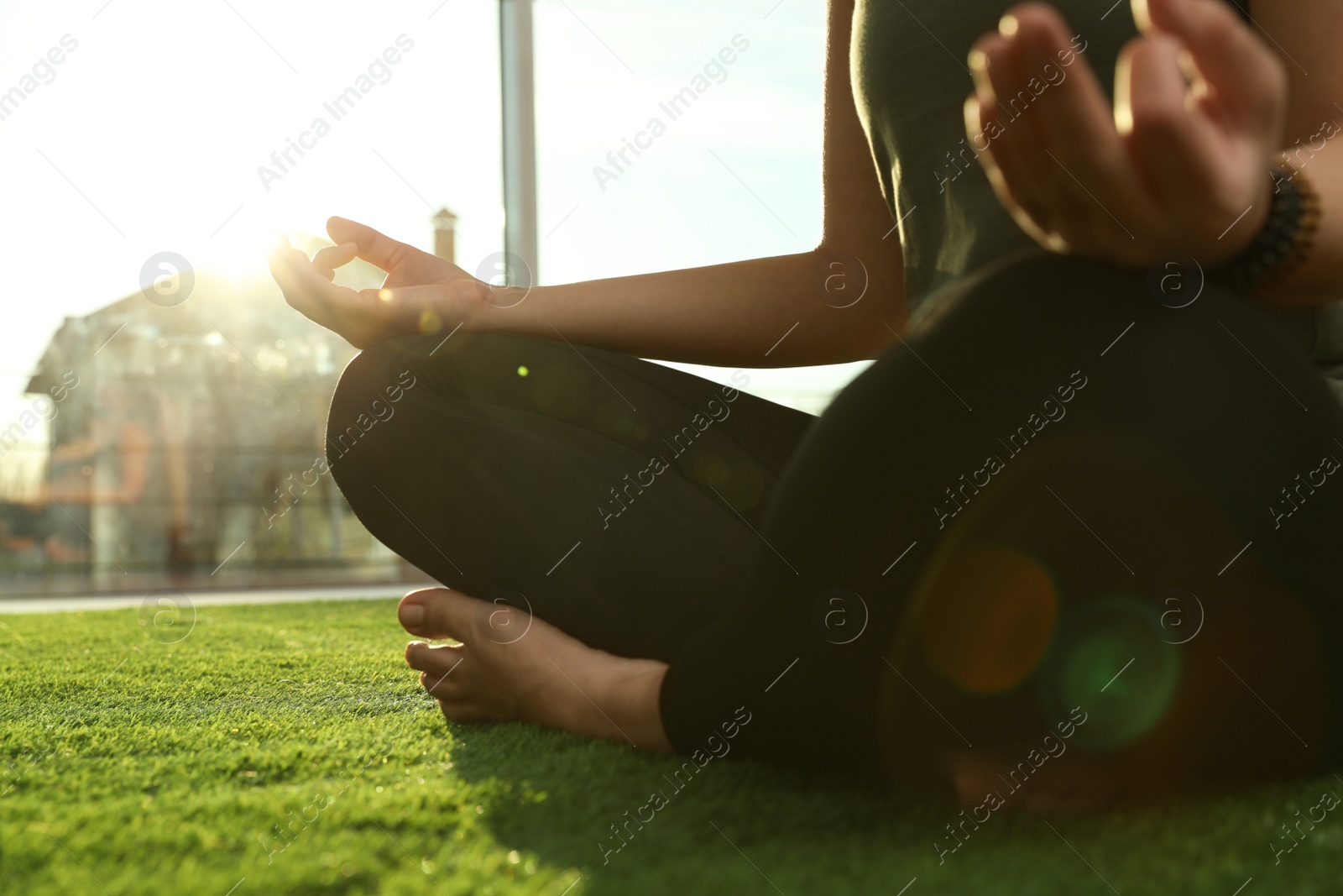 Photo of Young woman practicing yoga in sunlit room, closeup