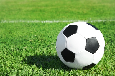 Photo of Soccer ball on fresh green football field grass. Space for text