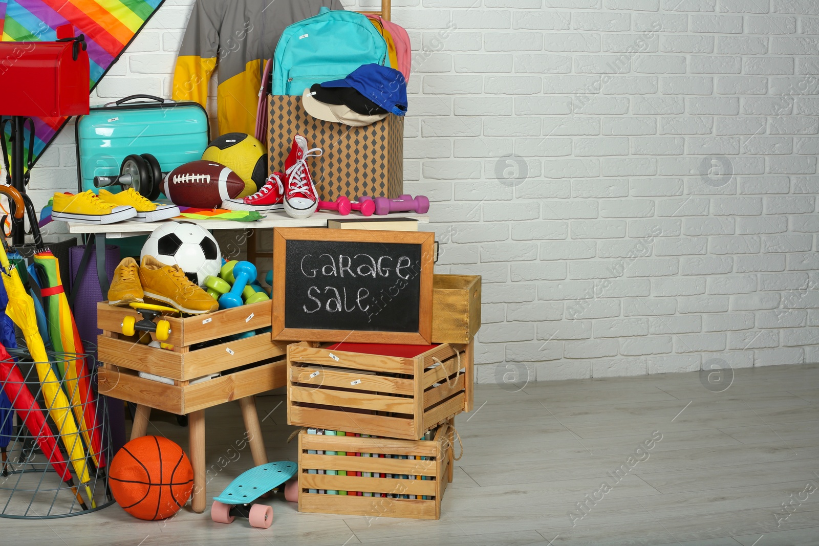 Photo of Sign Garage Sale written on blackboard near many different stuff indoors, space for text