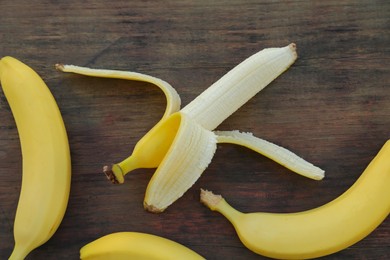 Photo of Delicious yellow bananas on wooden table, flat lay