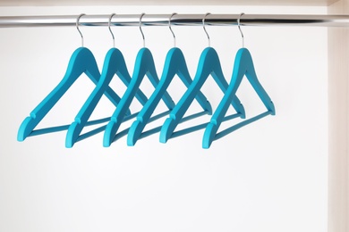 Clothes hangers on metal rail in wardrobe