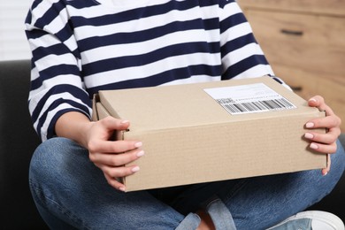 Photo of Woman with parcel at home, closeup. Online store