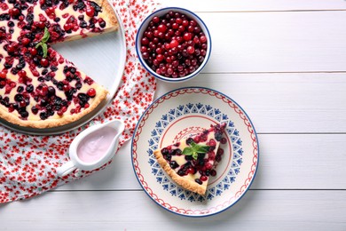 Photo of Delicious currant pie and fresh berries on white wooden table