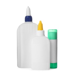 Photo of Different bottles and stick of glue on white background
